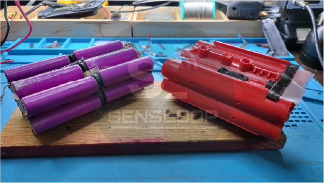 배터리 케이스에서 셀 팩을 완전히 분리한 모습. 내부 구성과 배선이 드러난 상태.