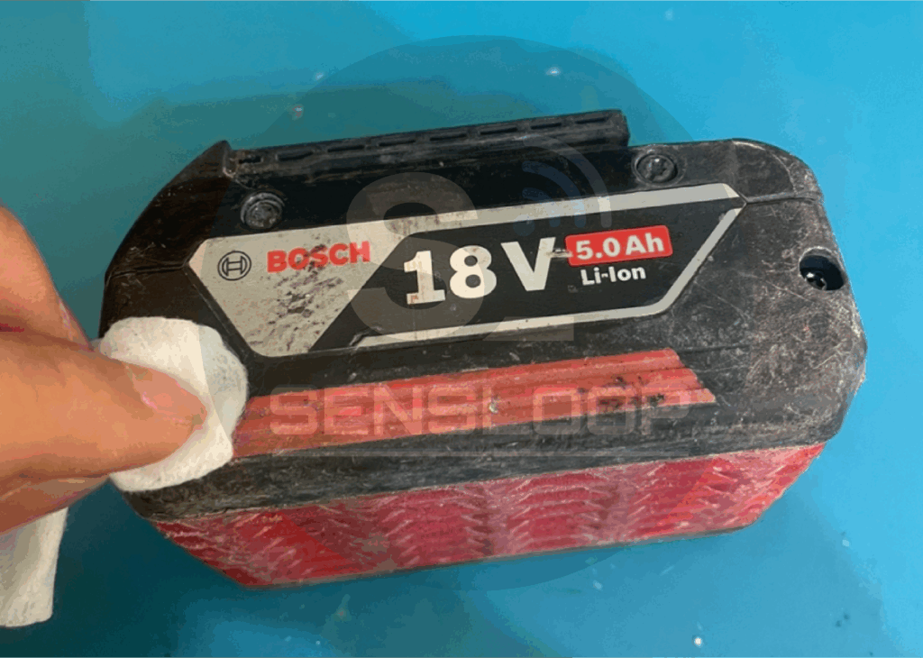 보쉬 18V 배터리 외부 케이스를 IPA로 닦아내며 세척 중인 장면