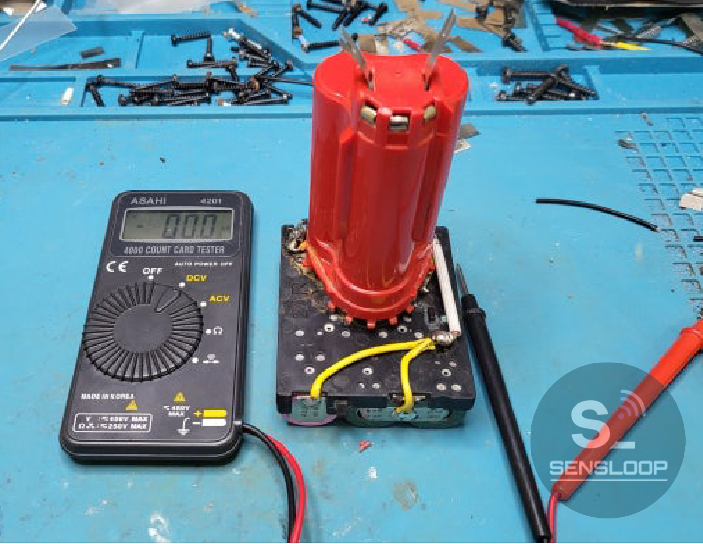 수리 완료 후 밀워키 M12 배터리팩의 전압을 멀티미터로 확인하는 장면. 셀 밸런스와 출력 상태를 점검하는 과정.